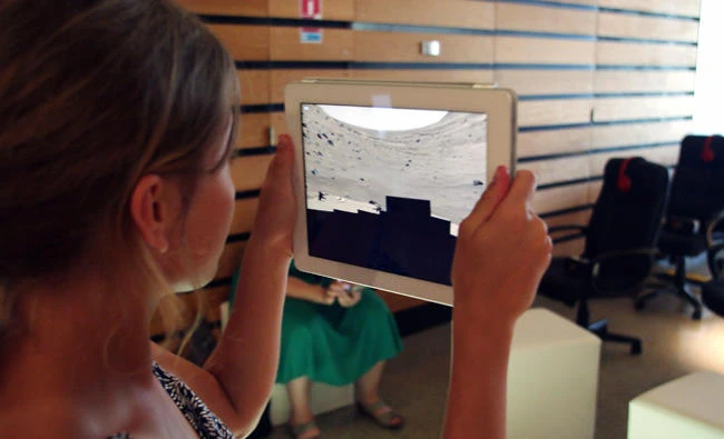 A woman holds a digital tablet during the Sunny Side of the Doc 2017, an international market dedicated to documentary film in La Rochelle on June 20, 2017. (AFP / XAVIER LEOTY)
