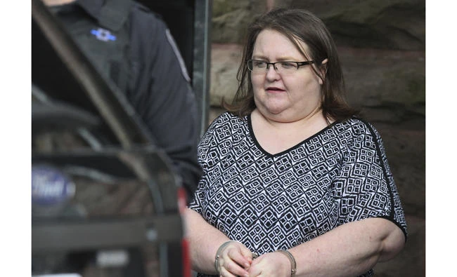 Elizabeth Wettlaufer is escorted by police from the courthouse in Woodstock, Ontario, Canada, on Monday after she was sentenced to life in prison with no eligibility for parole for 25 years for murdering eight seniors in her care. (Dave Chidley/The Canadian Press via AP)