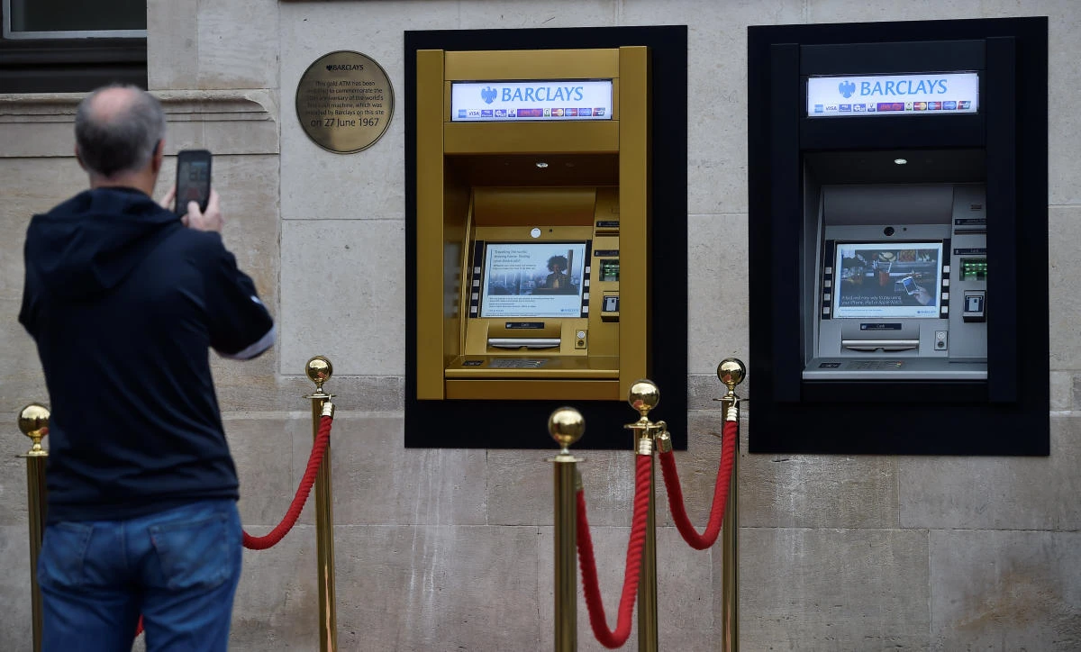A man photographs a golden ATM, marking the location of the first 'hole in the wall,' which opened fifty years ago, in Enfield, Britain June 27, 2017. (REUTERS)