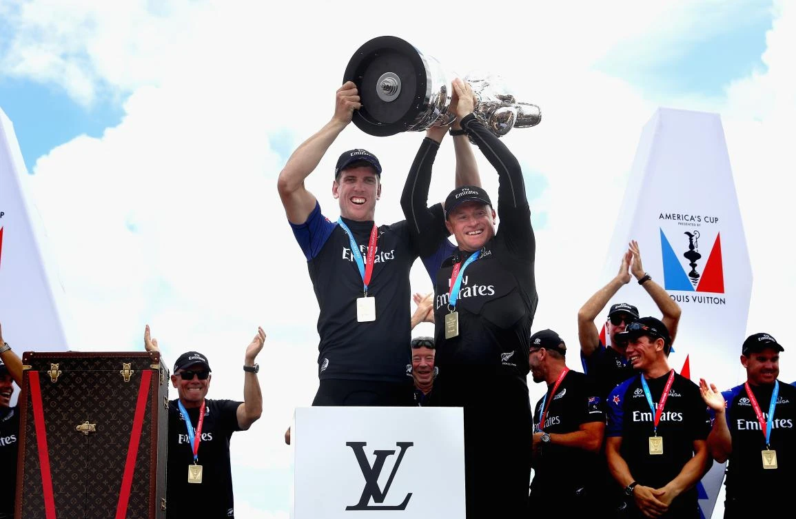 Peter Burling, left, and Glenn Ashby of Emirates Team New Zealand lift the trophy after winning race 9 against Oracle Team USA to win the America's Cup on day 5 of the America's Cup Match Presented by Louis Vuitton on Monday in Hamilton, Bermuda. (AFP)