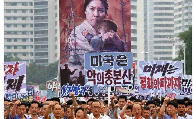 Tens of thousands of men and women pump their fists in the air and chant as they carry placards with anti-American propaganda slogans at Pyongyang's central Kim Il Sung Square on June 25, 2017, in North Korea. (AP)