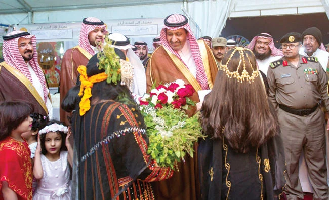 Baha Gov. Prince Husam bin Saud bin Abdul Aziz receives a bouquet from children at the opening ceremony of the Sheikh Ali Al-Hamrani Stadium and Sports Complex on Tuesday. (SPA)
