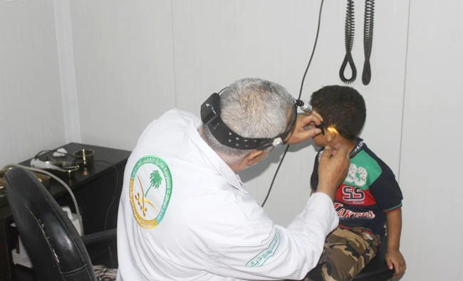 A boy is treated by a doctor at a medical center run by the Saudi Specialized Clinics at Zaatari camp in Jordan. (SPA)