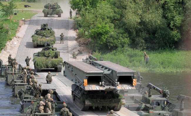 NATO advance force battalion group (EFP) demonstrates a water obstacle crossing during an International exercise "Iron Wolf 2017 /Saber Strike 2017' in Stasenai on June 20, 2017. The US House of Representatives voted overwhelmingly on Tuesday to reaffirm the NATO alliance’s guarantee that all members defend each other. (AFP / Petras Malukas)