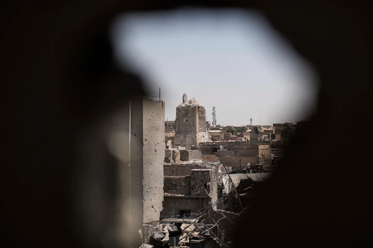The destroyed al-Nuri mosque is seen through a hole in the wall of a house retaken by Iraqi Special Forces during fighting against Daesh militants in the Old City of Mosul, Iraq. (AP)