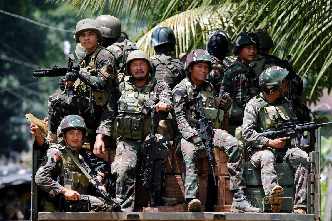 Philippines soldiers ride in trucks into the fighting zone as government troops continue their assault against insurgents from the Maute group in Marawi City on Tuesday. (Reuters)