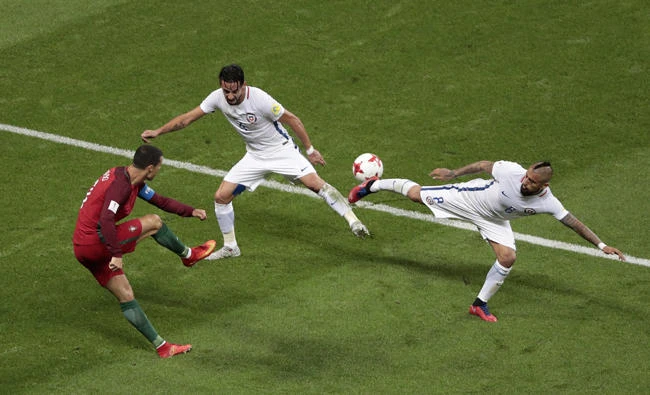 Chile's Arturo Vidal, right, and Chile's Mauricio Isla try to block a shot from Portugal's Cristiano Ronaldo during the Confederations Cup, semifinal soccer match between Portugal and Chile, at the Kazan Arena in Russia on Wednesday. (AP Photo/Dmitri Lovetsky)