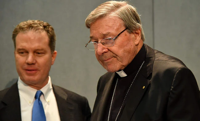 Australian Cardinal George Pell, right, flanked by Vatican press office director Greg Burke, arrives to deliver a statement at the Holy See Press Office, Vatican city, on Thursday after being charged with historical sex offenses. (AFP)
