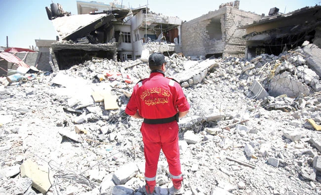 An Iraqi civil defense worker looks at rubble as his team searches for victims in western Mosul’s Zanjili district. (AFP)
