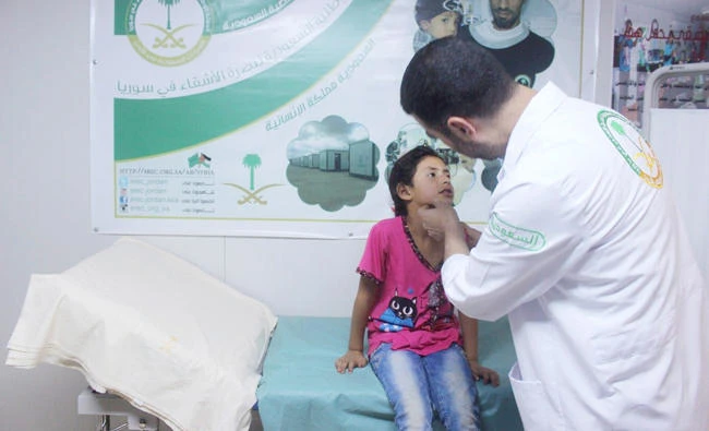 A girl is treated by a doctor at a medical center run by the Saudi Specialized Clinics at Zaatari camp in Jordan. (SPA)