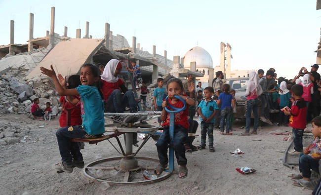 Syrian children, who fled their homes in Ghouta's al-Marj town, play amid the debris of buildings in the town of al-Nashabiyah in the eastern Ghouta region, a rebel stronghold east of the capital Damascus on June 27, 2017. (AFP / AMER ALMOHIBANY)