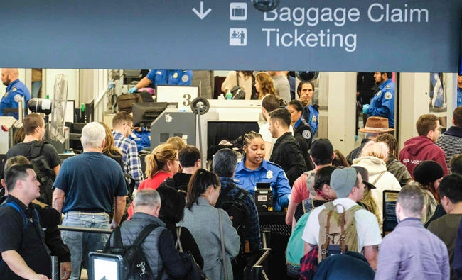 This file photo taken on Dec. 20, 2016 shows holiday travelers in line to go through the security checkpoint at the Los Angeles International Airport, California. The US Department of Homeland Security (DHS) announced on June 28, 2917, it would implement tough new security rules for all airlines flying into the country, but held off from a threatened expansion of its carry-on laptop ban. (AFP / RINGO CHIU)