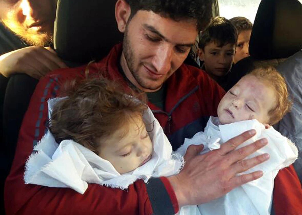 Abdul-Hamid Alyousef, 29, holds his twin babies who were killed during a chemical weapons attack, in Khan Sheikhoun. (Alaa Alyousef via AP, File)