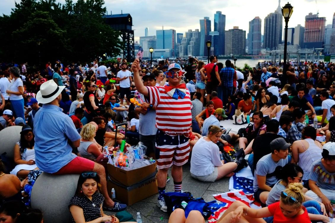 People wait for the start of the annual Macy's 4th of July fireworks show from Queens, New York on July 4, 2017. / AFP / EDUARDO MUNOZ ALVAREZ