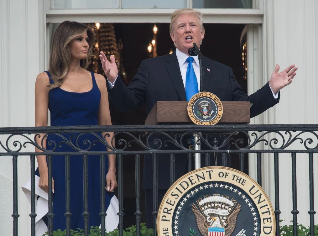 US President Donald Trump speaks next to First Lady Melania Trump during the military families picnic at the White House in Washington, DC, on July 4, 2017. / AFP / NICHOLAS KAMM