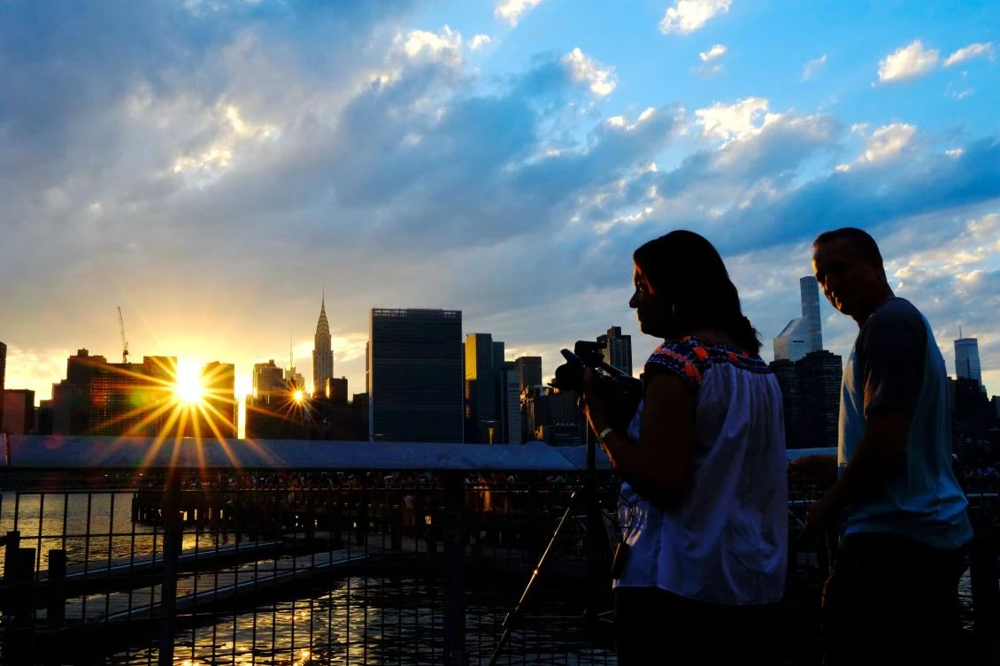People wait for the start of the annual Macy's 4th of July fireworks show from Queens, New York on July 4, 2017. / AFP / EDUARDO MUNOZ ALVAREZ