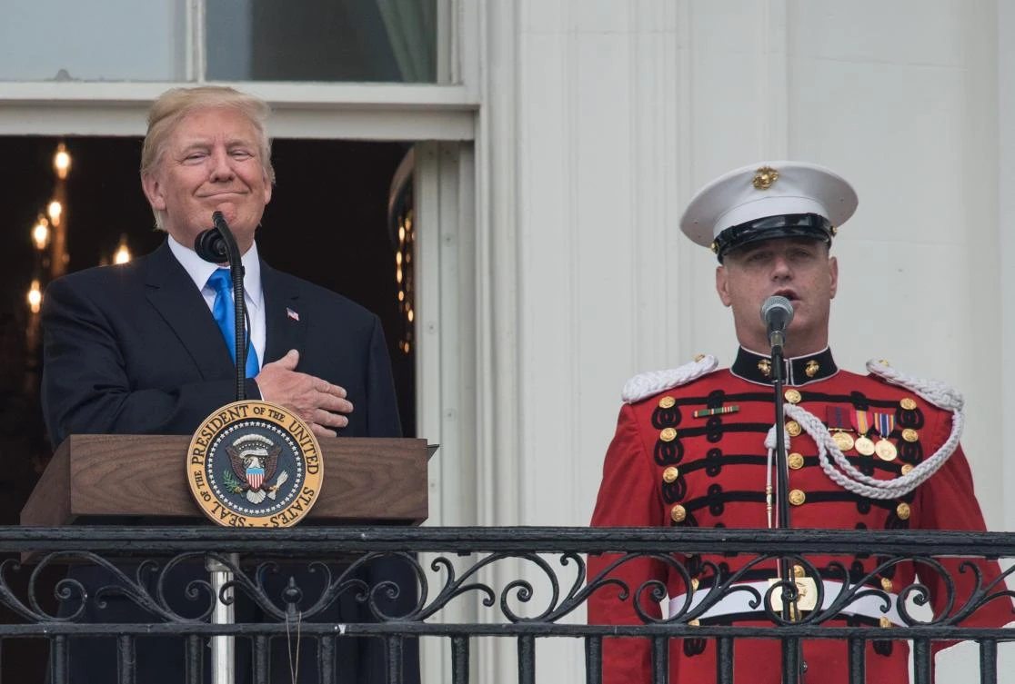 US President Donald Trump listens to the national anthem during the military families picnic at the White House in Washington, DC, on July 4, 2017. / AFP / NICHOLAS KAMM