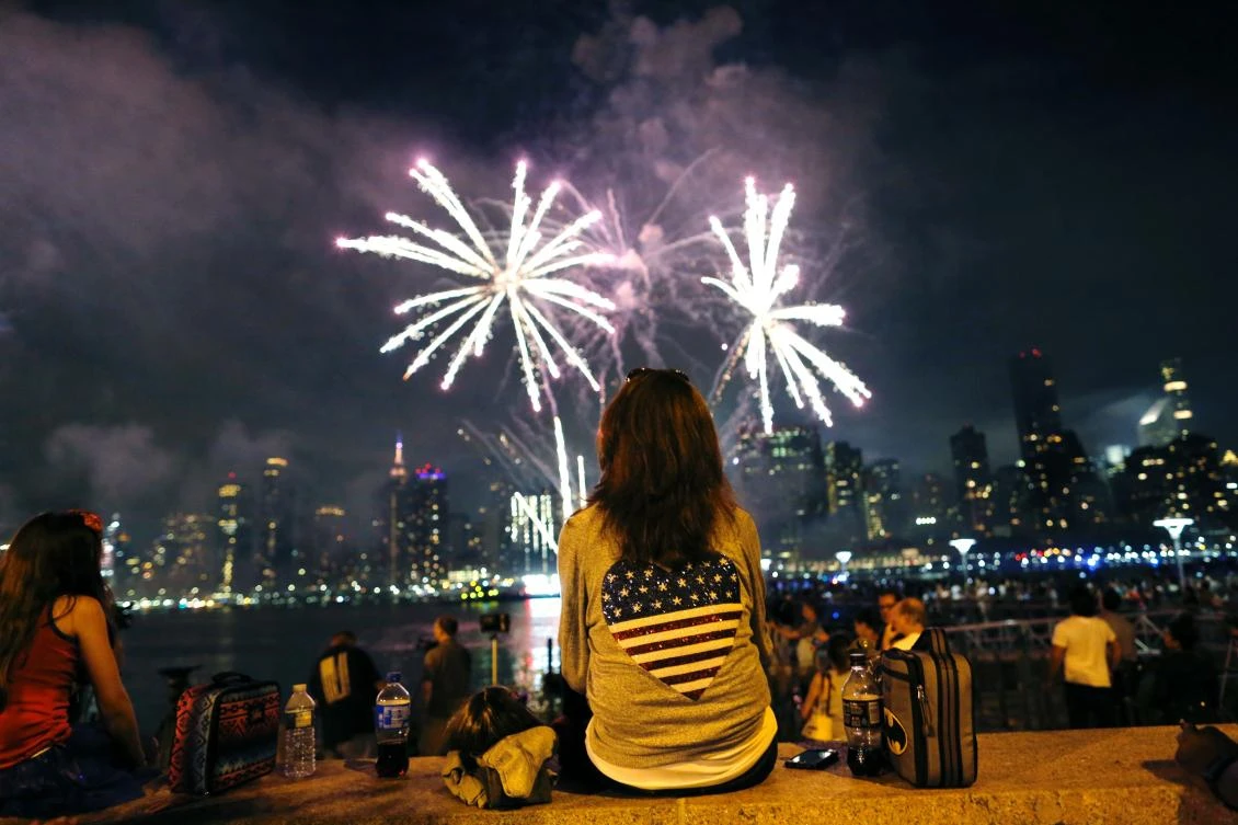 People watch the annual Macy's 4th of July fireworks show from Queens, New York on July 4, 2017. / AFP / EDUARDO MUNOZ ALVAREZ