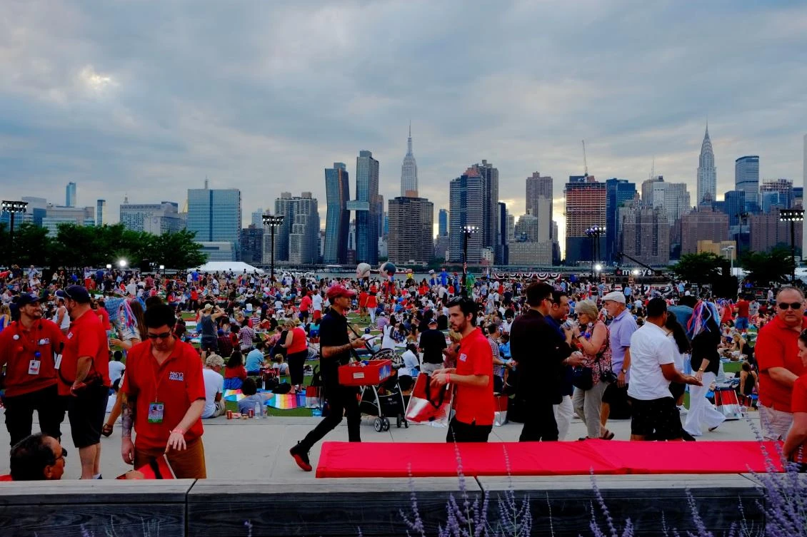 People wait for the start of the annual Macy's 4th of July fireworks show from Queens, New York on July 4, 2017. / AFP / EDUARDO MUNOZ ALVAREZ