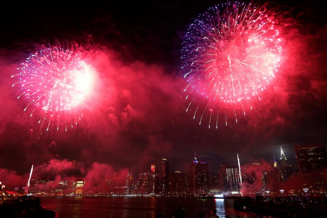 People watch the annual Macy's 4th of July fireworks show from Queens, New York on July 4, 2017. / AFP / EDUARDO MUNOZ ALVAREZ