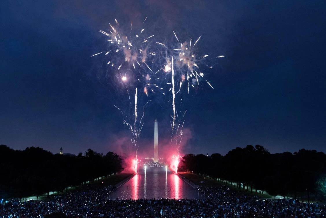 People watch fireworks as they celebrate US independence day on July 4, 2017 in Washington, DC. / AFP / Brendan Smialowski