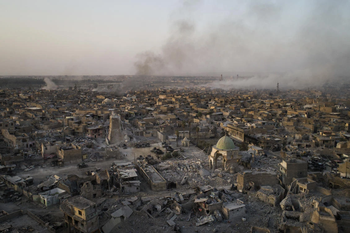 In this July 4, 2017 photo, the heavily damaged al-Nuri mosque sits as smoke from explosions billow from the Old City of Mosul, Iraq. Iraq’s U.S.-backed forces succeeded in wresting Mosul from the Islamic State group but at the cost of enormous destruction. The nearly 9-month fight culminated in a crescendo of devastation _ the blasting of the historic Old City to root out the militants’ final pockets. (AP Photo/Felipe Dana)