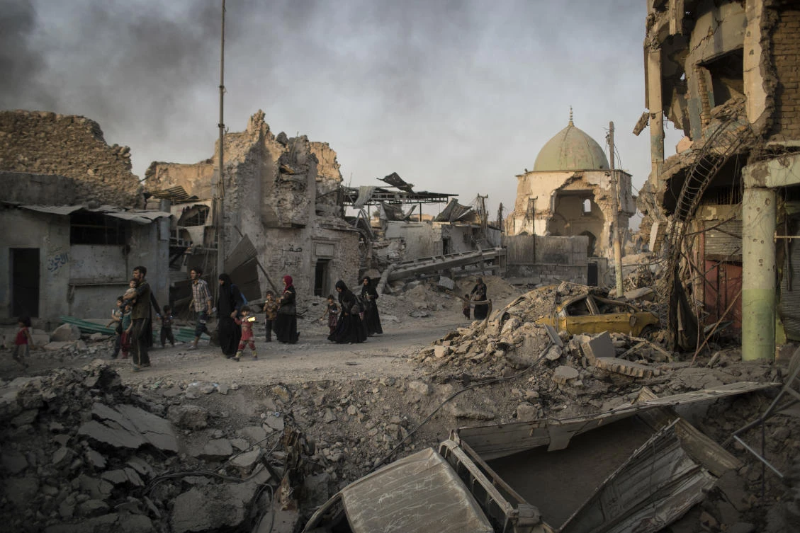 In this July 4, 2017 photo, fleeing Iraqi civilians walk past the heavily damaged al-Nuri mosque during fights between Iraqi security forces and Islamic State militants in the Old City of Mosul, Iraq. Iraq’s U.S.-backed forces succeeded in wresting Mosul from the Islamic State group but at the cost of enormous destruction. The nearly 9-month fight culminated in a crescendo of devastation _ the blasting of the historic Old City to root out the militants’ final pockets. (AP Photo/Felipe Dana)