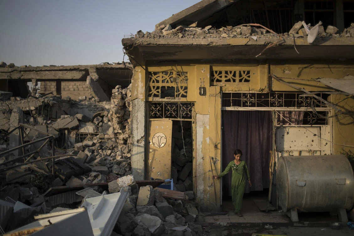 In this July 13, 2017 photo, Samaher Saddam cleans the entrance of her damaged house in the west side of Mosul, Iraq. The 9-month fight to defeat the Islamic State group in Mosul ended in a crescendo of devastation: bombardment that damaged or destroyed a third of its historic Old City in just three weeks. The cost of uprooting the militants was the destruction of large swaths of Iraq’s second largest city, leaving a population that is displaced, exhausted and potentially embittered if there is no reconstruction. (AP Photo/Felipe Dana)