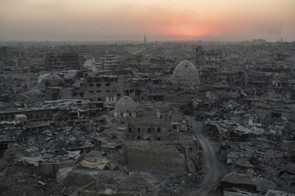 The sun sets behind destroyed buildings in the west side of Mosul, Iraq on Tuesday, July 11, 2017. The 9-month fight to defeat the Islamic State group in Mosul ended in a crescendo of bombardment that damaged or destroyed a third of its historic Old City in just three weeks. The cost of uprooting the militants was the destruction of large swaths of Iraq's second largest city, leaving a population that is displaced, exhausted and potentially embittered if there is no reconstruction. (AP Photo/Felipe Dana)