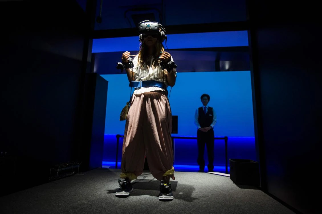 A woman plays a virtual reality (VR) Dragon Ball game at the Bandai Namco game facility of VR Zone Shinjuku in Tokyo on July 22, 2017. / AFP / Behrouz MEHRI