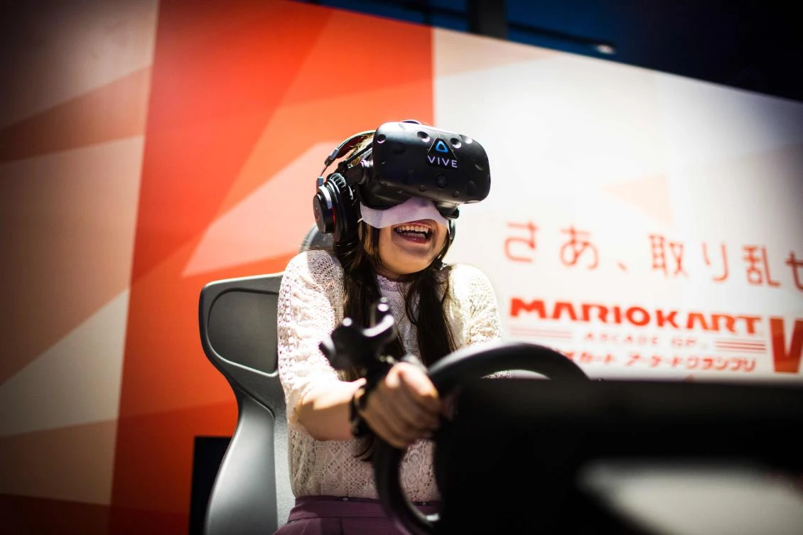 A woman plays a virtual reality (VR) Mario Kart game at the Bandai Namco game facility of VR Zone Shinjuku in Tokyo on July 22, 2017. / AFP / Behrouz MEHRI