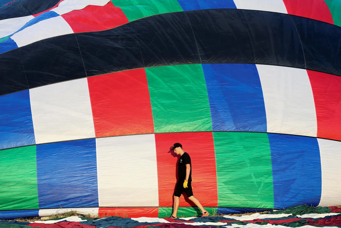 A man walks next to his hot air balloon before participating in a hot air ballooning event in Todi, Italy, July 29, 2017. REUTERS/Alessandro Bianchi