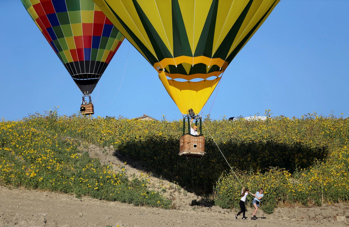 Women tow their hot air balloon during a hot air ballooning event in Todi, Italy, July 29, 2017. REUTERS/Alessandro Bianchi
