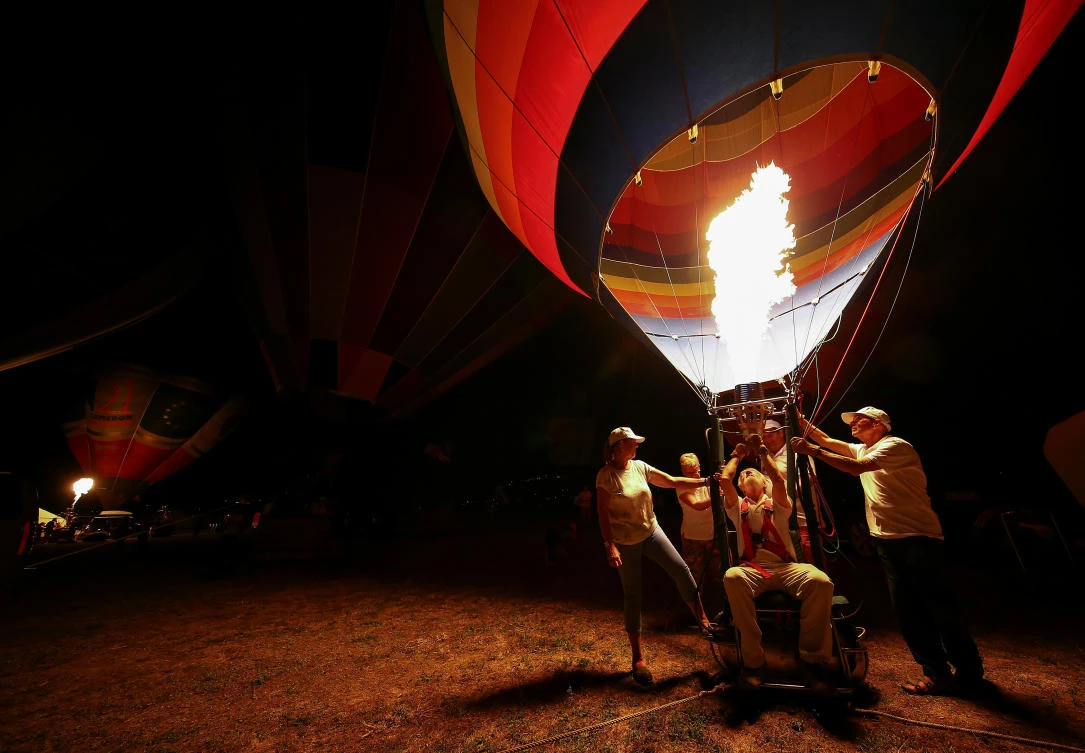 Crew members fire up their hot air balloon during an Italian hot air ballooning event in Terni, Italy, July 28, 2017. REUTERS/Alessandro Bianchi