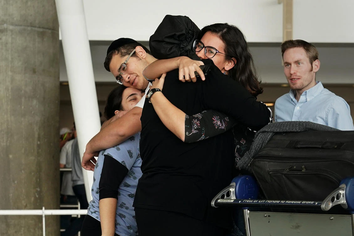 People hug after arriving in advance of the incoming travel ban to the US. (Reuters)