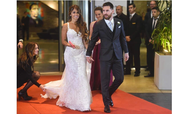 Argentine football star Lionel Messi and bride Antonella Roccuzzo pose for photographers just after their wedding at the City Centre Complex in Rosario, Santa Fe province, Argentina on June 30, 2017. (AFP / EITAN ABRAMOVICH)