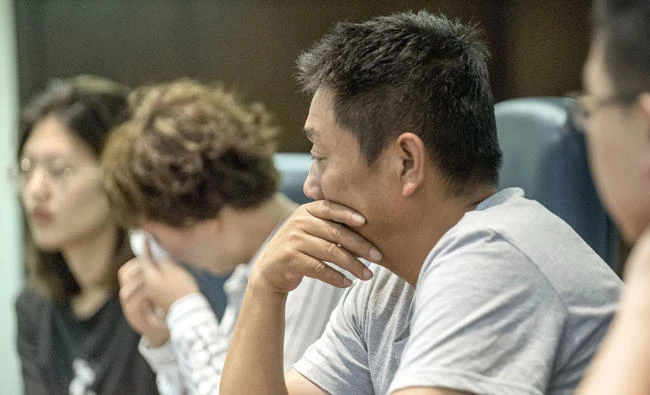 In this June, 22, 2017 file photo, Ronggao Zhang, center, father of missing University of Illinois scholar Yingying Zhang, listens as he joins, from left, Yingying's best friend, Yige Yang, aunt Liqin Ye, and boyfriend, Xiaolin Hou, far right, for an interview at The Champaign News-Gazette in Champaign, Illinois. (Heather Coit/The News-Gazette via AP File)