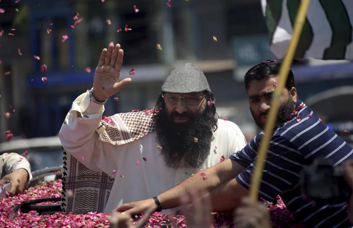 Syed Salahuddin, center, top leader of the Hizbul Mujahideen, waves to his supporters who showered rose petals upon his arrival for a press conference in Muzaffarabad, the capital of Pakistani controlled Kashmir, Saturday, July 1, 2017. A prominent Kashmir rebel leader recently blacklisted as a terrorist by the United States vowed to continue his armed struggle against the Indian forces in the disputed Himalayan region until the region of liberated from New Delhi. (AP)