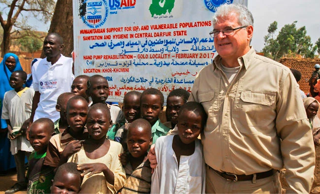 In this file photo, Steven Koutsis, right, the United States' top envoy in Sudan, posing for a picture with Sudanese children and villagers in the war-torn town of Golo. Sudan has made "positive" steps towards meeting Washington's conditions for permanently lifting 20-year-old sanctions on the African country, the US envoy to Khartoum told AFP in an interview. (AFP)