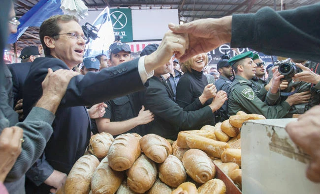 Israeli Labor party leader Isaac Herzog, left, visits a market in Tel Aviv in this file photo. (AP)
