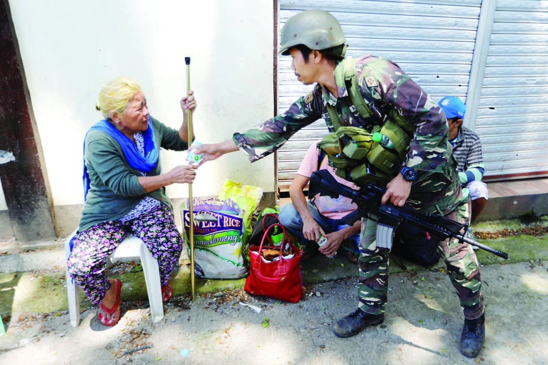 Filipino 62-year-old Linda receives water after being rescued from the combat zone where she and her family were trapped more than 5 weeks in Marawi city on Satruday. (Reuters)
