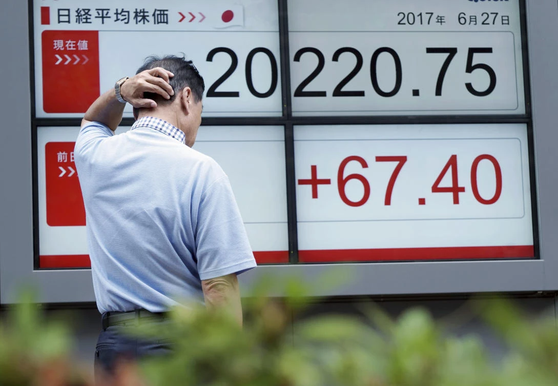 A man looks at an electronic stock board showing Japan's Nikkei 225 index at a securities firm in Tokyo. (AP)