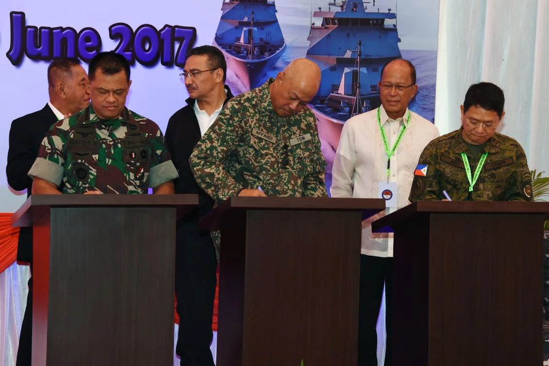 This handout photograph taken and released by the Indonesian National Armed Forces on June 19, 2017 shows (front L to R) Indonesia's military chief Gatot Nurmantyo, Malaysia's armed forces chief Raja Mohamed Affandi, and Philippines' Chief of staff of the armed forces Eduardo Ano, (back L to R) Indonesia's minister of defence Ryamizard Ryacudu, Malaysia's minister of defence Hishammuddin Hussein, and Philippines' Secretary of National Defense Delfin Lorenzana, signing agreements for the "trilateral coordinated maritime patrol" in Tarakan, North Kalimantan. Indonesia, Malaysia and the Philippines began joint naval patrols in their region on June 19 as threats from extremist groups increase. The "trilateral coordinated maritime patrol" was launched amid continuing battles between Philippine troops and Islamist gunmen loyal to the Islamic State group, who have seized part of the city of Marawi in the southern Philippine island of Mindanao.