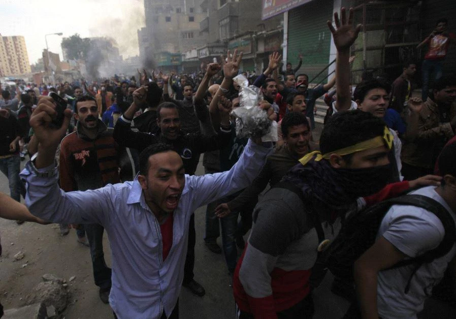 Supporters of the Muslim Brotherhood and ousted Egyptian President Mohamed Mursi shout slogans in front of riot police and army and their supporters, during clashes at El-Talbyia near Giza square, south of Cairo, November 29, 2013. (REUTERS)