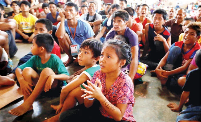 Displaced Marawi residents react as they watch the box fight between Manny Pacquiao of the Philippines and Australia's Jeff Horn during the WBO World Welterweight Title, at an evacuation center in Baloi, Philippines on Sunday. (Reuters)