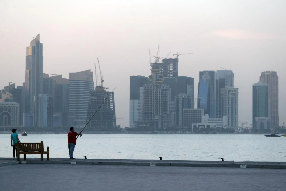 A man fishes off the corniche in Doha on Sunday amid dark skies. Qatar remains isolated after four of its former allies severed diplomatic and travel ties with it for its alleged support of terrorism and sleeping with regional foe Iran. (AFP photo)