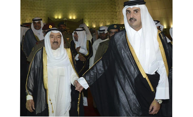 Kuwait's Emir Sheikh Sabah Al Ahmad Al Sabah, left, holds the hand of Qatar's Emir Sheikh Tamim bin Hamad Al Thani in Doha on June 7, 2017 during a visit to Doha. (KUNA via AP, File)