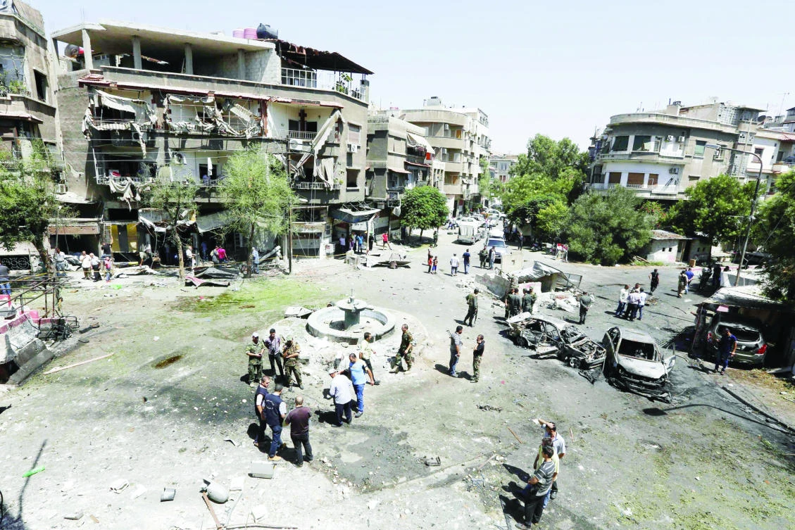 People inspect the site of a suicide bomb attack in the eastern Tahrir Square district of Damascus on Sunday. (AFP)