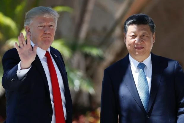 US President Donald Trump (R) and Chinese President Xi Jinping pause for photographs at Mar-a-Lago, on Friday. (AP)