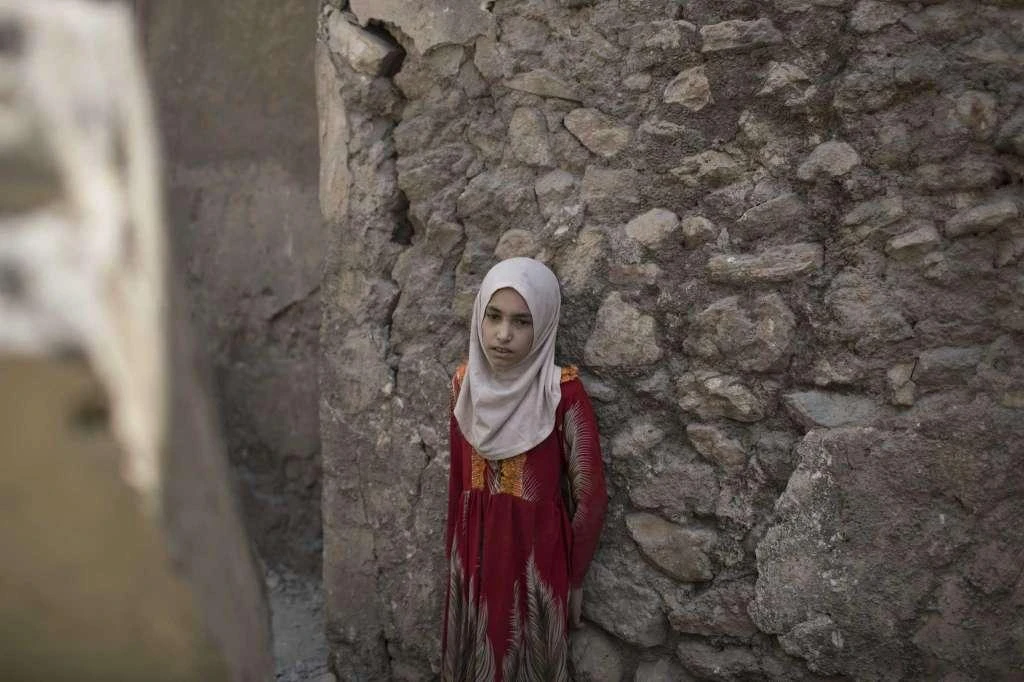 A girl stops in exhaustion while fleeing through an alley, as Iraqi Special Forces continue their advance against Daesh militants, in the Old City of Mosul, Iraq, Sunday, July 2, 2017. (AP)